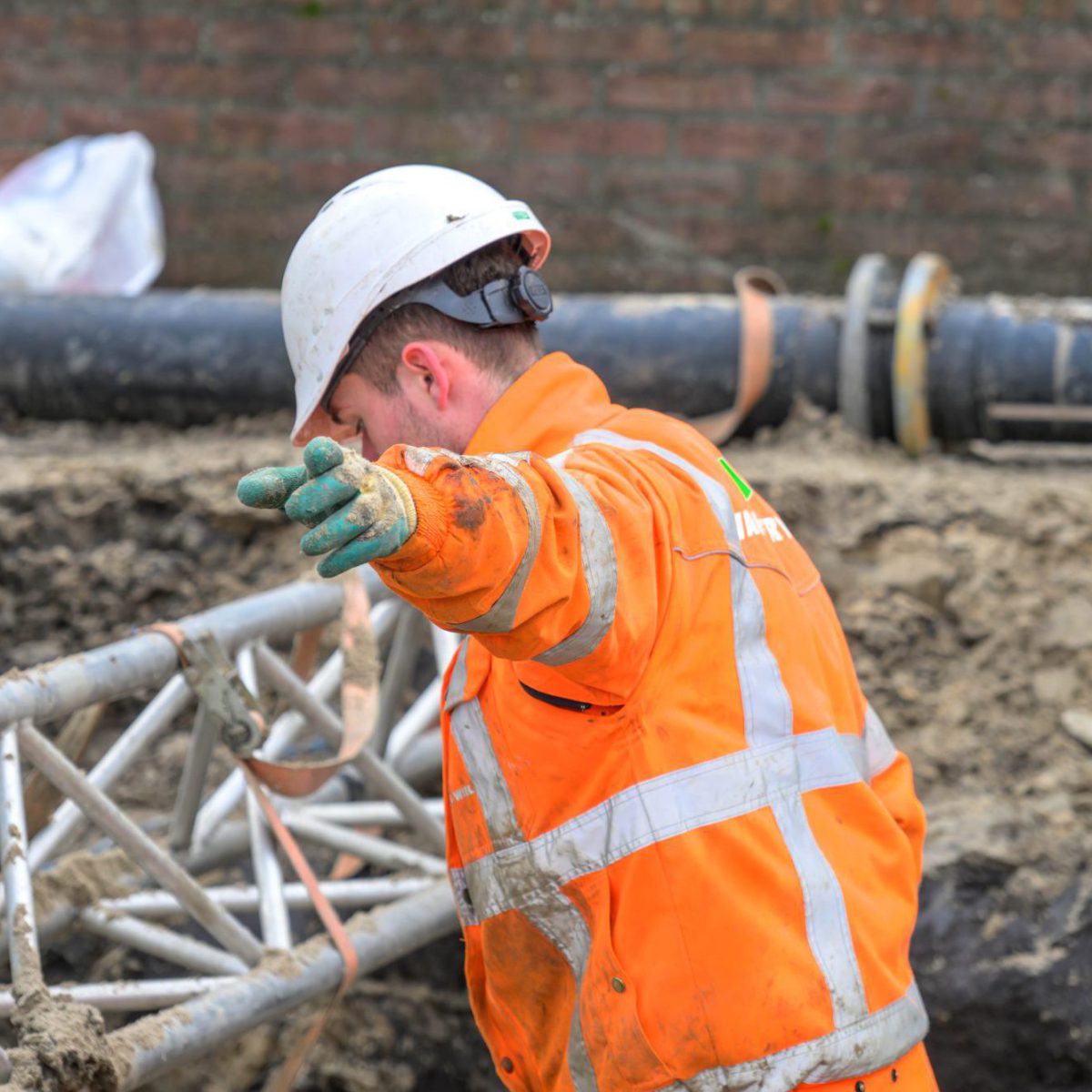 Grondwerker in werkkleren op projectlocatie.
